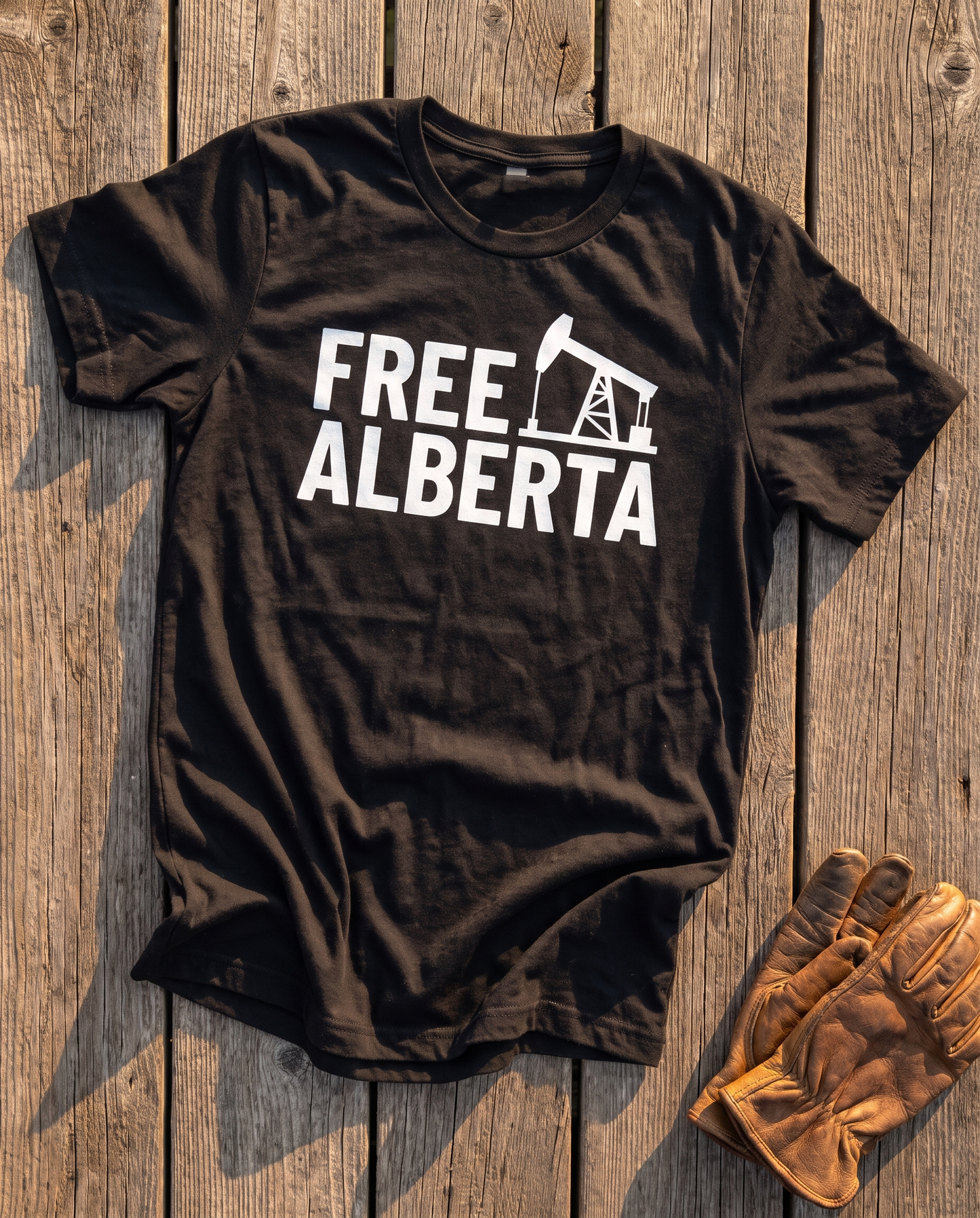 Free Alberta pumpjack tee black flat lay barn wood
