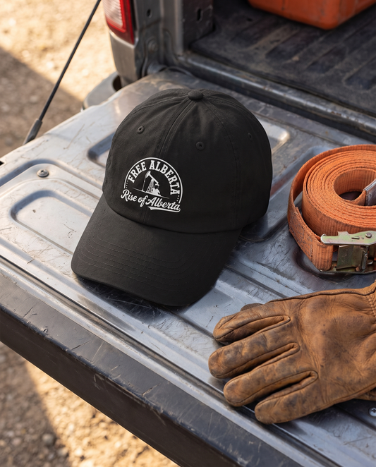 Black Free Alberta baseball cap flat lay on work truck tailgate with leather gloves