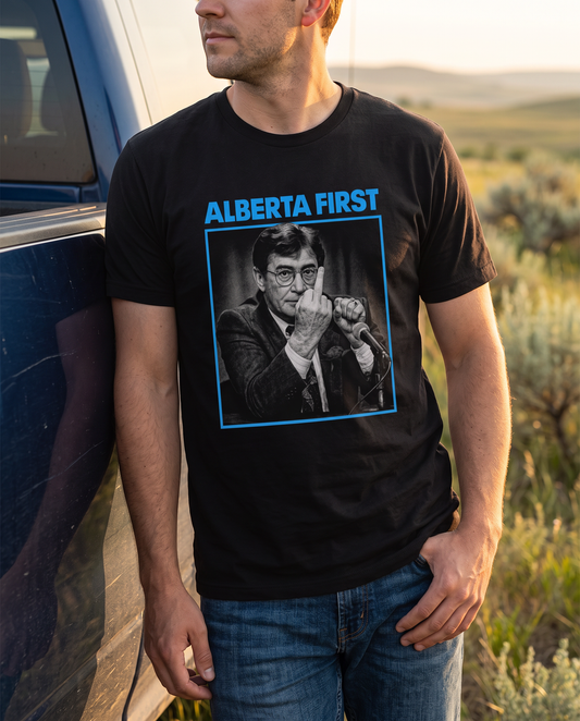 Man wearing Alberta First The Gesture black t-shirt by pickup truck at golden hour