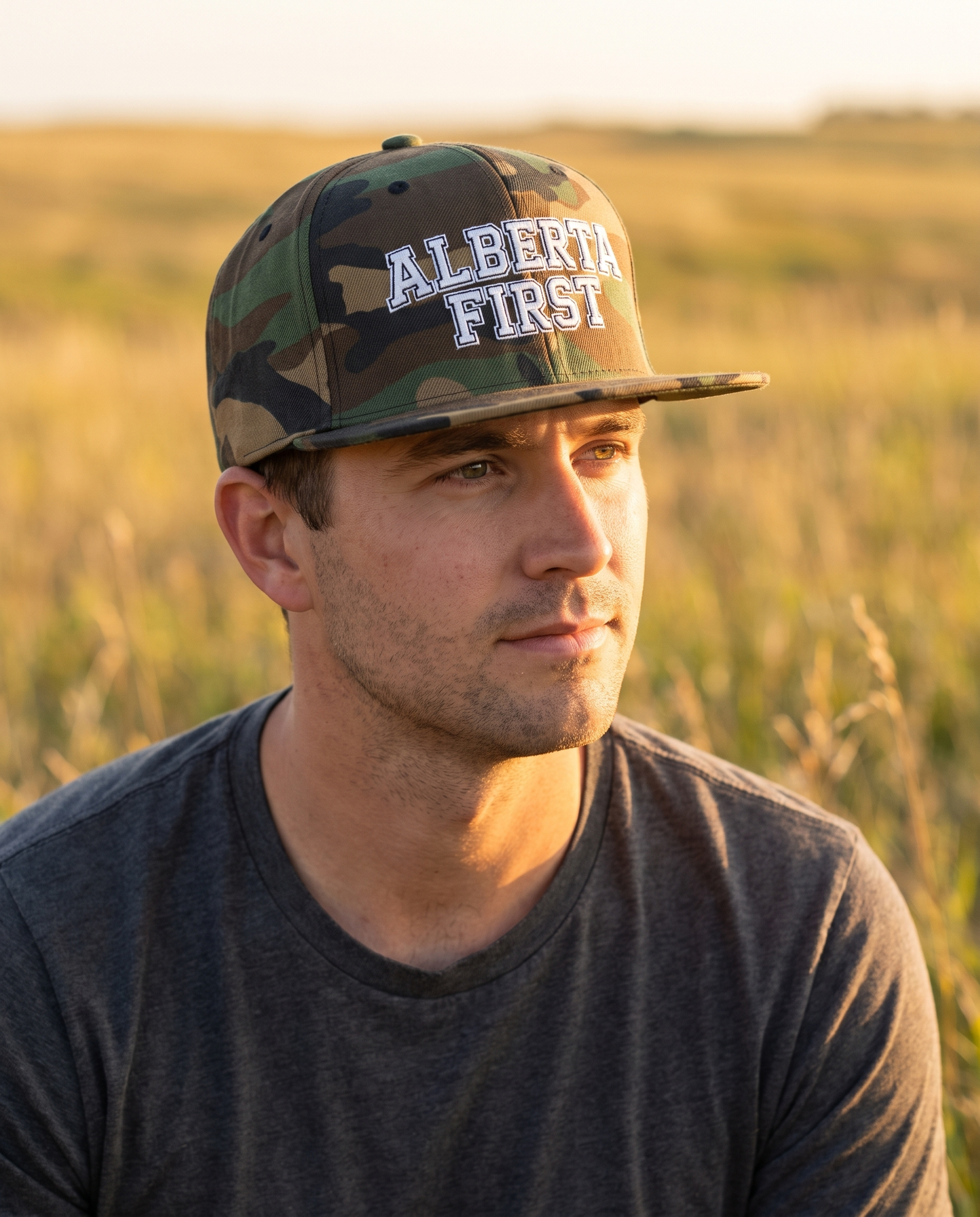 Man wearing Alberta First green camo snapback at golden hour