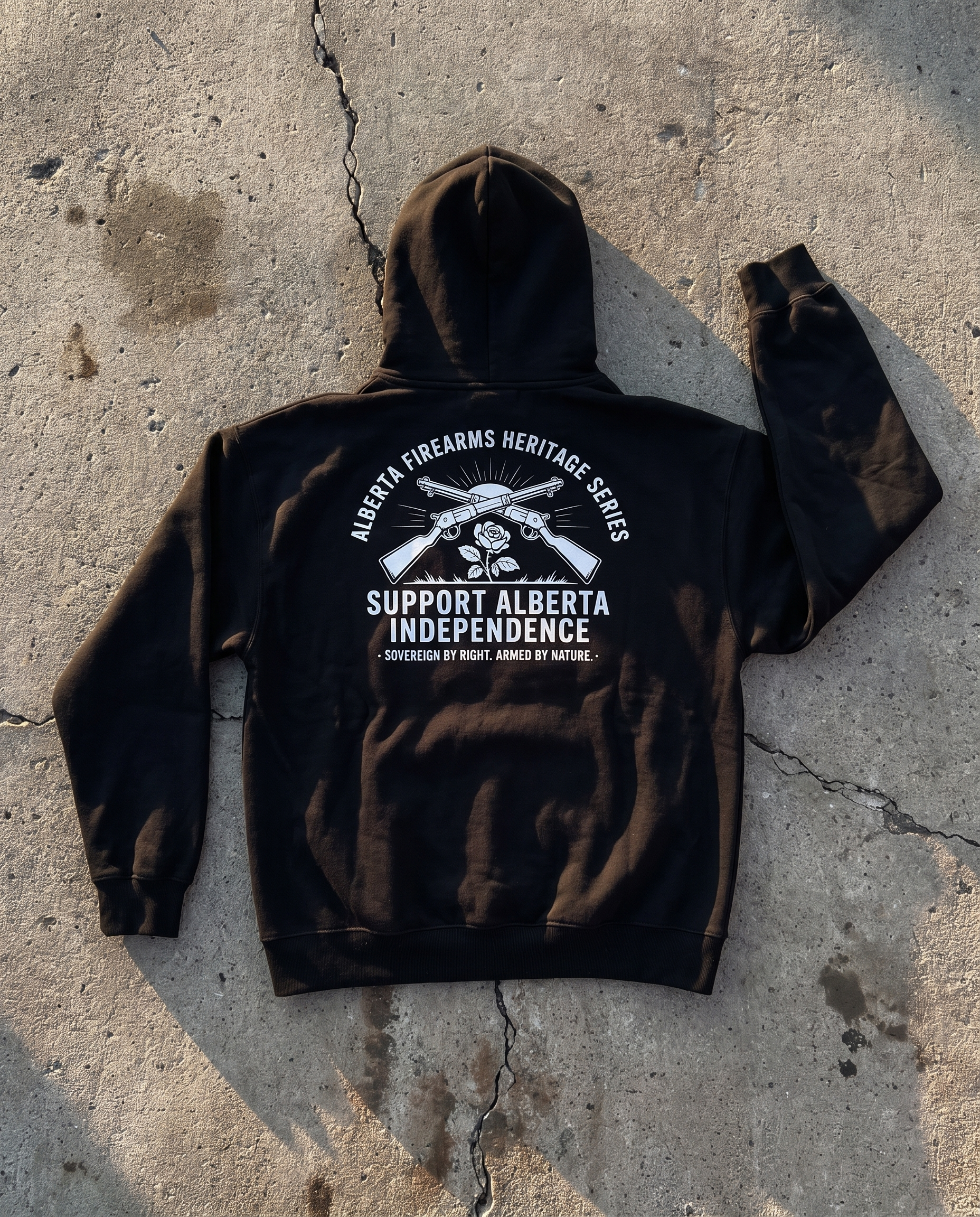 Firearm Heritage black hoodie back print flat lay on cracked concrete