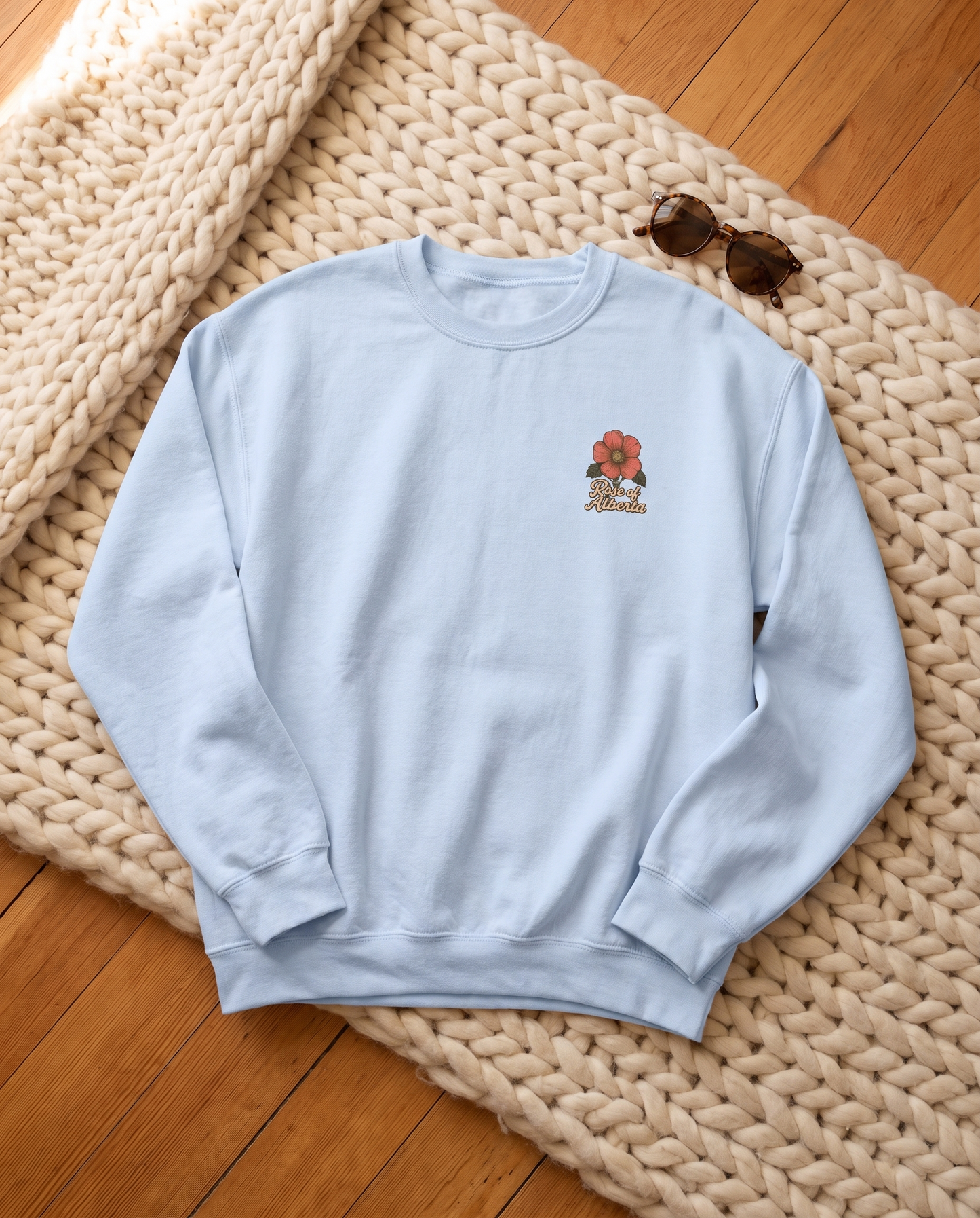 Alberta Wild and Free crewneck light blue front with chest crest flat lay