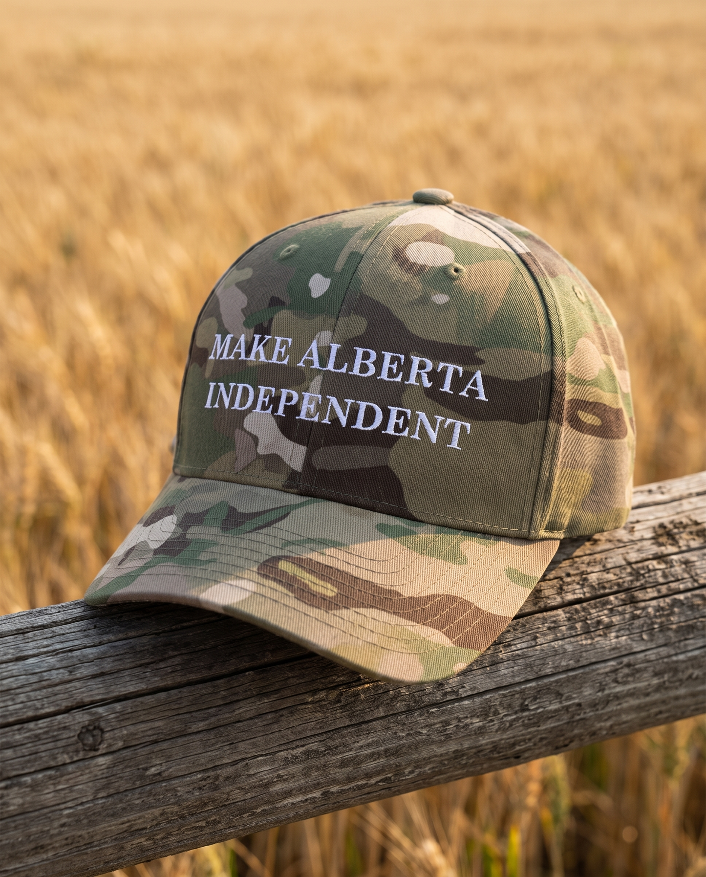 Make Alberta Independent embroidered cap multicam green on fence rail