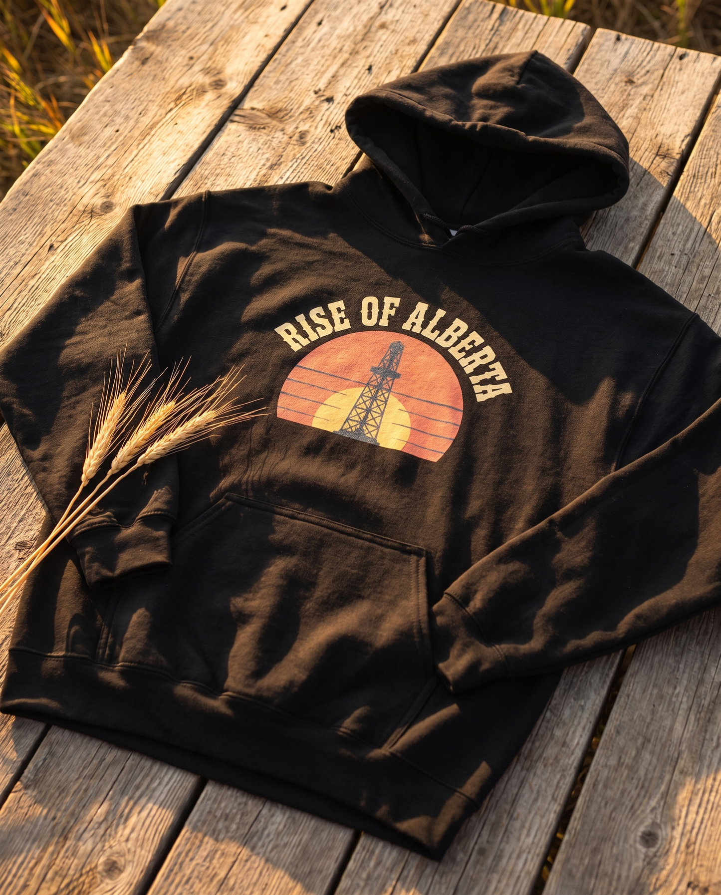Rise of Alberta Sunrise Hoodie black flat lay on barn boards