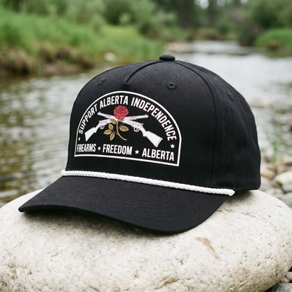 Alberta Firearms Freedom Rope Hat in black on a river stone beside a creek