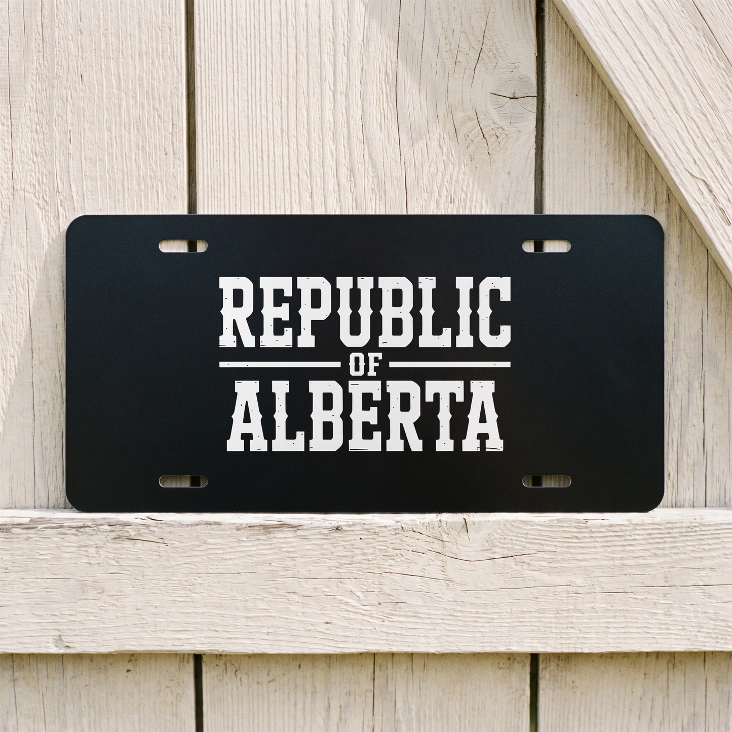 Black Republic of Alberta vanity plate against weathered barn board