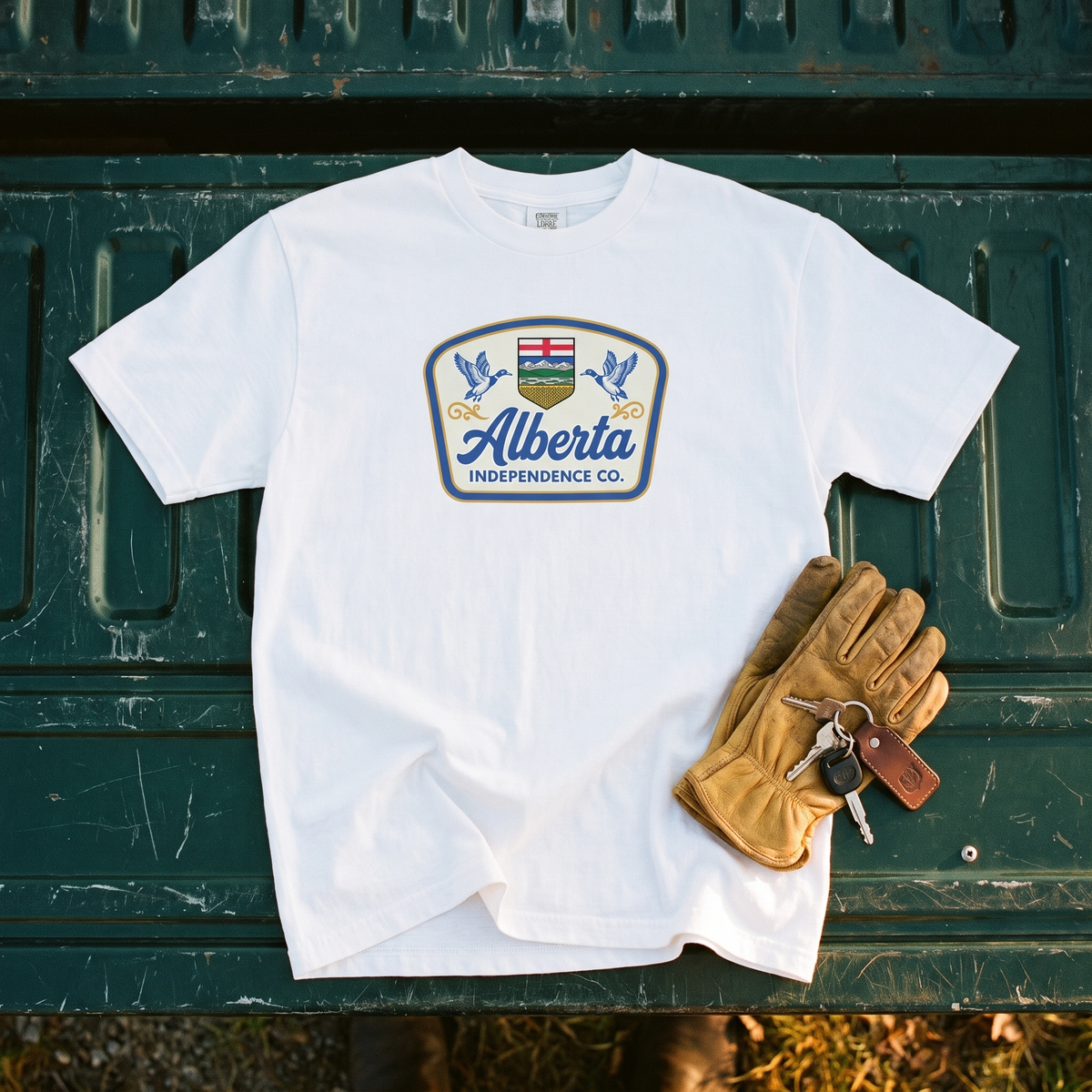 Heritage Tee in White, flat lay on a truck tailgate