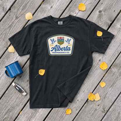 Heritage Tee in Black, flat lay on weathered planks