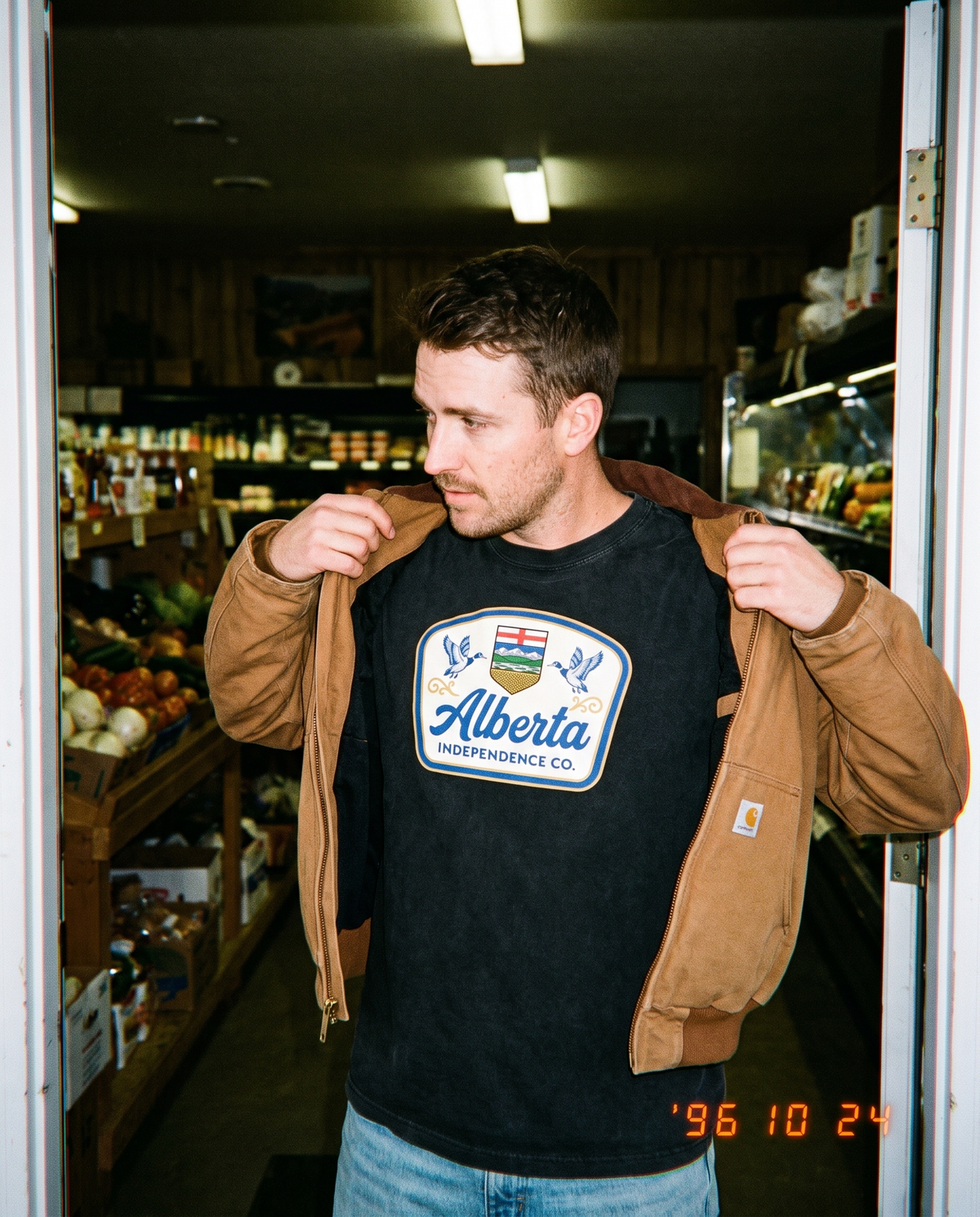 Heritage Tee in Black worn in a farm shop doorway