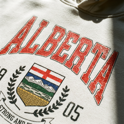 Close detail of the Alberta crest chest print on bone cream fleece
