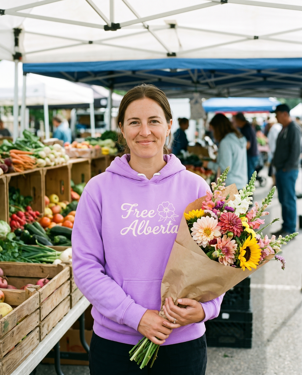 Woman wearing the Neon Violet Free Alberta hoodie at a farmers market