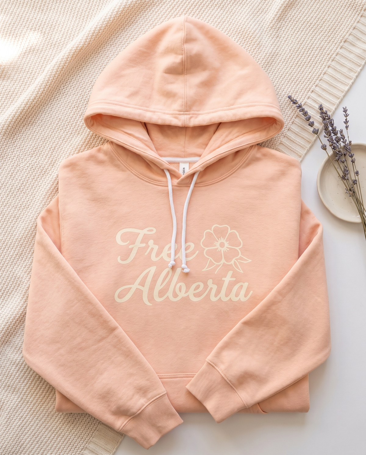 Free Alberta lightweight hoodie in Peachy flat lay on a knit blanket
