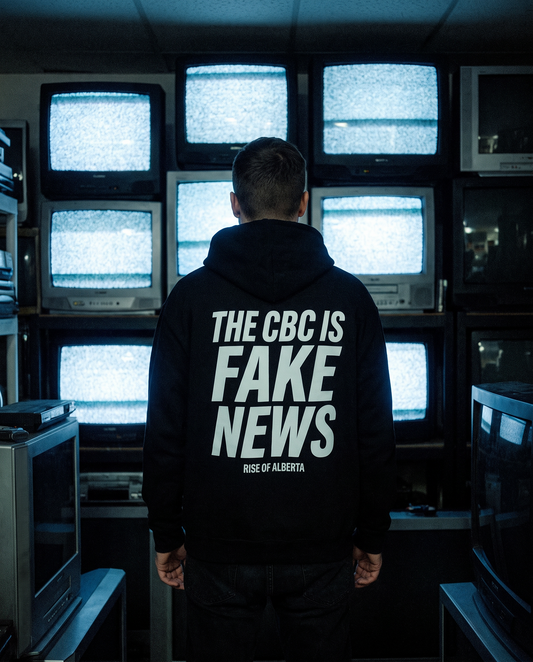 Man in the black CBC Is FAKE NEWS hoodie facing a wall of old televisions showing static